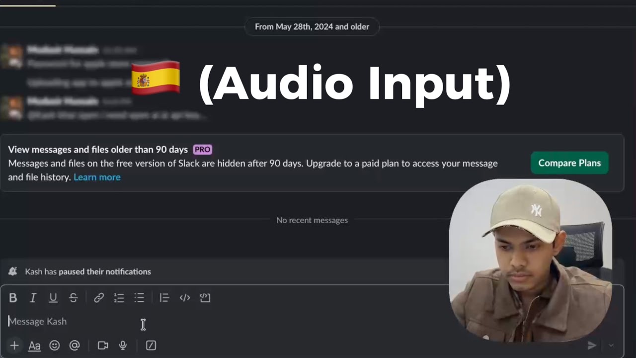 Thumbnail of the demo video LumeVoice embeds on its own homepage: a dark-theme Slack workspace with the message composer focused, a Spanish flag and the caption Audio Input, and a webcam inset of the presenter. No LumeVoice interface is visible in this frame